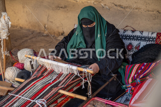 المحافظة على التراث الشعبي السعودي، يوم بدينا ٢٢ فبراير، صناعة تقليدية تاريخية، منتج وطني محلي, حرفة ومهنة يدوية قديمة، سيدة عربية خليجية سعودية ترتدي العباءة والبرقع تقوم بنسج وغزل الصوف, ذكرى تاسيس الدوله السعوديه الاولى ١٧٢٧م