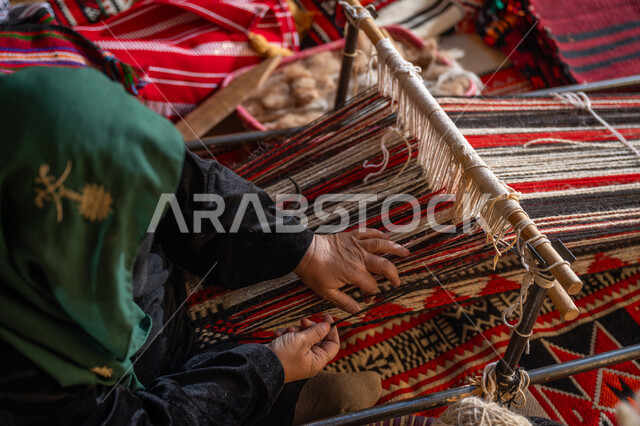 يوم بدينا ٢٢ فبراير، صناعة تقليدية تاريخية، منتج وطني محلي, ذكرى تاسيس الدوله السعوديه الاولى ١٧٢٧م، صورة من الاعلى لسيدة عربية خليجية سعودية ترتدي العباءة والبرقع تقوم بنسج وغزل الصوف, مهنة وحرفة يدوية قديمة، إحياء التراث الشعبي السعودي