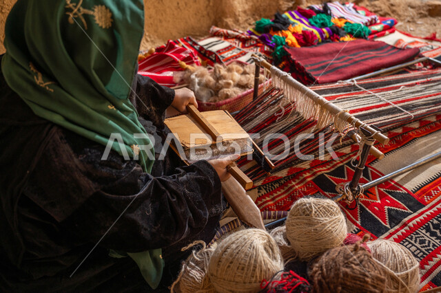 ذكرى تأسيس الدولة السعودية الأولى 1727م, يوم بدينا 22 فبراير, حرفة و مهنه يدوية تاريخيه, المحافظة على التراث السعودي، الاستعداد لنسج وغزل الخيوط, صورة مقربة من الجانب لسيدة عربيه خليجية سعودية ترتدي العباءه السوداء تقوم بتمشيط الصوف