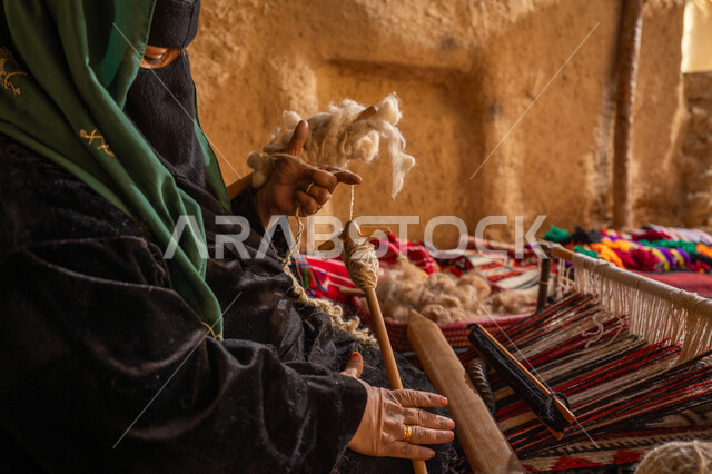ذكرى تأسيس الدولة السعودية الأولى 1727م, حرفة يدوية تاريخيه, المحافظة على التراث الشعبي السعودي, الشغف في ممارسة مهنة الغزل و النسج, يوم بدينا 22 فبراير, صورة مقربة من الجانب لامرأة عربيه خليجية سعودية ترتدي البرقع و العباءه السوداء تقوم بلف خيوط الصوف