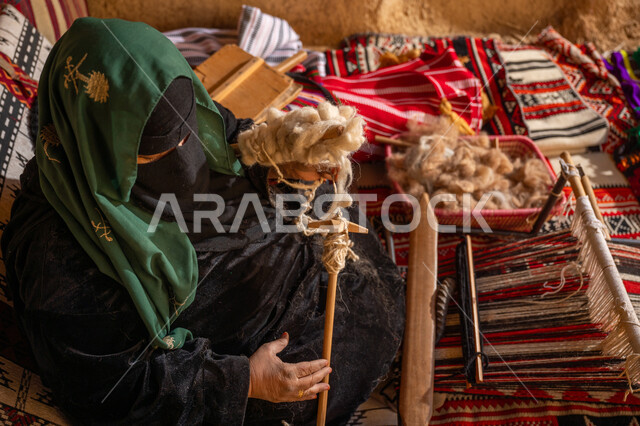 ذكرى تأسيس الدولة السعودية الأولى 1727م, الشغف في ممارسة مهنة الغزل و النسج, يوم بدينا 22 فبراير, امرأة عربيه خليجية سعودية ترتدي البرقع و العباءه السوداء تقوم بلف خيوط الصوف, حرفة يدوية تاريخيه, المحافظة على التراث الشعبي السعودي