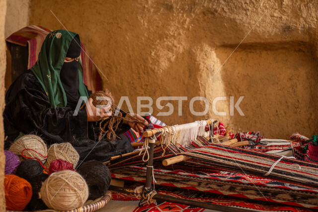 ذكرى تأسيس الدولة السعودية الأولى 1727م, المحافظة على التراث الشعبي السعودي, حرفة يدوية تاريخيه, الشغف في ممارسة مهنة الغزل و النسج, امرأة عربيه خليجية سعودية ترتدي البرقع و العباءه السوداء تقوم بلف خيوط الصوف, يوم بدينا 22 فبراير