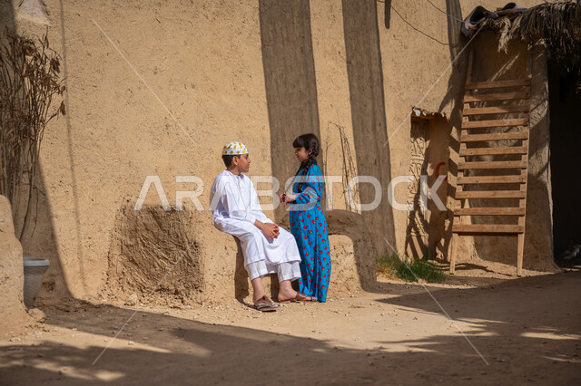 Having a good time talking and discussing with the brother, a historical village built of bricks, the day we started, February 22, a boy and his sister, two Saudi Gulf Arabs wearing traditional costumes, sitting in an old mud house and exchanging conversation, commemorating the founding of the first Saudi state 1727 AD