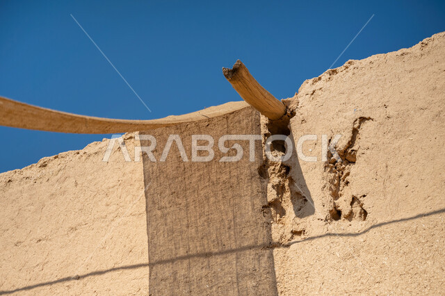 بيت تراثي مبني من الطين على الطراز القديم, المباني الأثرية التاريخية في المملكة, ذكرى يوم تأسيس الدولة السعودية الأولى 1727 م، يوم بدينا 22 فبراير, صورة مقربة للدعامة الخشبية للمظلة القماشية، أقمشة ممتدة بين البيوت لتوفير الظل بطريقة قديمة متوارثة