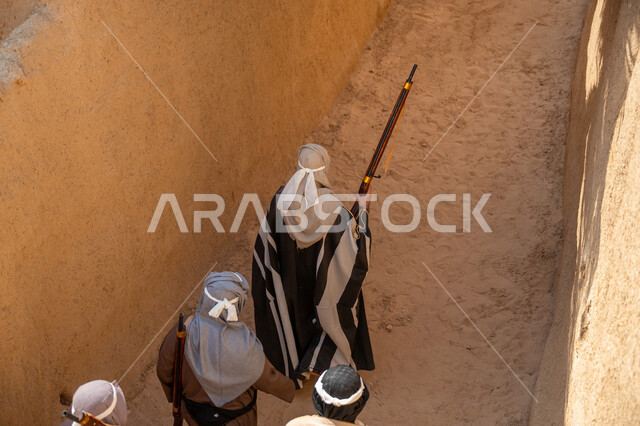 الحفاظ على تاريخ وتراث المملكة، القتال والحرب بالبنادق للحماية وتأسيس الدولة السعودية الأولى 1727م، مجموعة رجال عرب خليجيين سعوديين يرتدون الزي الشعبي التقليدي يحملون البندقيات، الحراسة والمراقبة للدفاع عن الوطن، يوم بدينا 22 فبراير