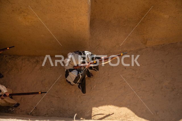 الحفاظ على تاريخ وتراث المملكة، القتال والحرب بالبنادق للحماية وتأسيس الدولة السعودية الأولى 1727م، مجموعة رجال عرب خليجيين سعوديين يرتدون الزي الشعبي التقليدي يحملون البندقيات، الحراسة والمراقبة للدفاع عن الوطن، يوم بدينا 22 فبراير