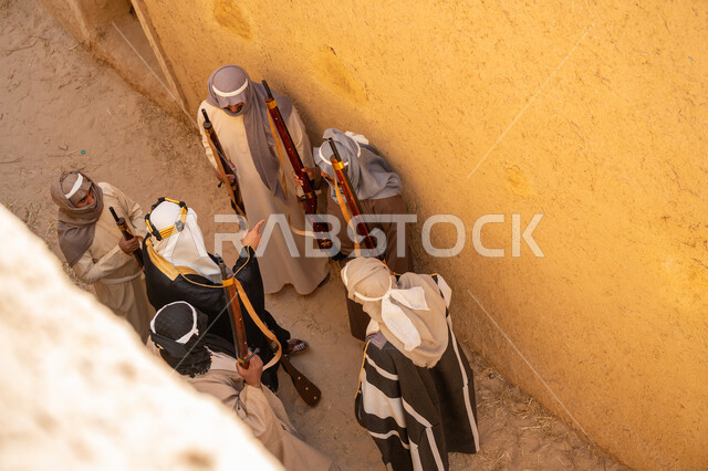 الحوار والتخطيط للحرب، يوم بدينا 22 فبراير، القتال بالبنادق للحماية وتأسيس الدولة السعودية الأولى 1727م، مجموعة رجال عرب خليجيين سعوديين ملثمين يرتدون الزي الشعبي التقليدي يحملون البندقيات، الحراسة والمراقبة للدفاع عن الوطن