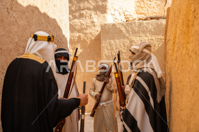 The day we started, February 22, fighting with guns to protect and establish the first Saudi state 1727 AD, a group of masked Saudi Gulf Arab men wearing traditional folk costume carrying guns, guarding and monitoring to defend the homeland, dialogue and planning for war
