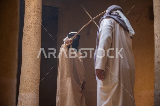 The concept of war and defending the homeland, preserving the history and heritage of the Kingdom, ancient war tools, sword fighting for protection and the establishment of the first Saudi state 1727 AD, two Saudi Gulf Arab men wearing traditional costumes dueling with swords in a mud house, the day we started, February 22