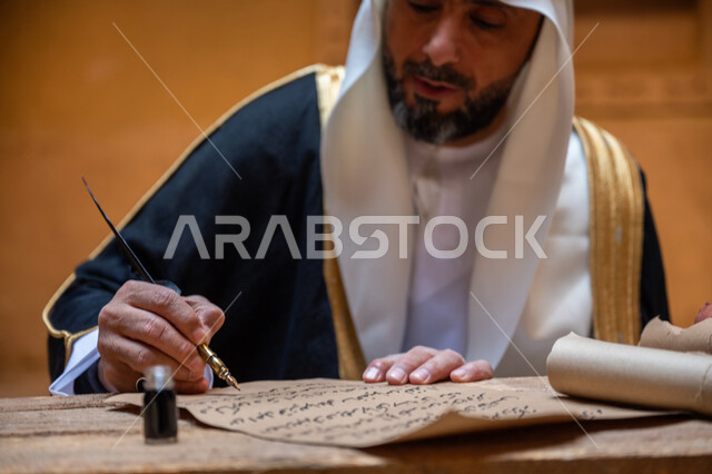 يوم بدينا 22 فبراير، ارتداء الزي الشعبي في المناسبة الوطنية، صورة مقربة لرجل عربي خليجي سعودي يرتدي الغترة والبشت يمسك بيده الريشة يقوم بالكتابة على مخطوطة جلد تاريخية، الخطابات والمراسلات التراثية لتأسيس الدولة السعودية الأولى 1727م، الفخر بأصالة المملكة