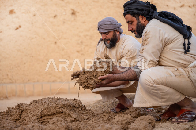 الفخر والاعتزاز بالتراث السعودي العريق, تشييد وبناء البيوت الطينية التراثية التاريخية, إحياء ذكرى يوم التأسيس1727 م, بناء الدولة السعودية الأولى، يوم بدينا 22 فبراير, عاملان عربيان يقومان بعجن الطين بأيديهم
