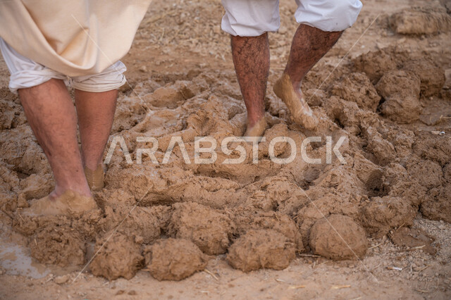 Pride and honor in the ancient Saudi heritage, construction and building of historical heritage mud houses, commemorating the founding day 1727 AD, building the first Saudi state, two Arab workers kneading clay with their feet, the day we started, February 22