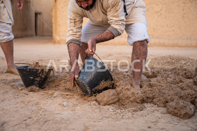 بناء الدولة السعودية الأولى, يوم بدينا 22 فبراير, الفخر والاعتزاز بالتراث السعودي العريق, عاملان عربيان يقومان بخلط الطين ومواد البناء, تشييد وبناء البيوت الطينية التراثية التاريخية, إحياء ذكرى يوم التأسيس1727 م