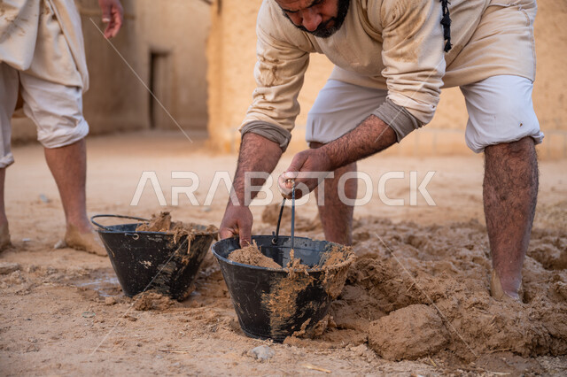 إحياء ذكرى يوم التأسيس1727 م, بناء الدولة السعودية الأولى, يوم بدينا 22 فبراير, الفخر والاعتزاز بالتراث السعودي العريق, عاملان عربيان يقومان بخلط الطين ومواد البناء, تشييد وبناء البيوت الطينية التراثية التاريخية