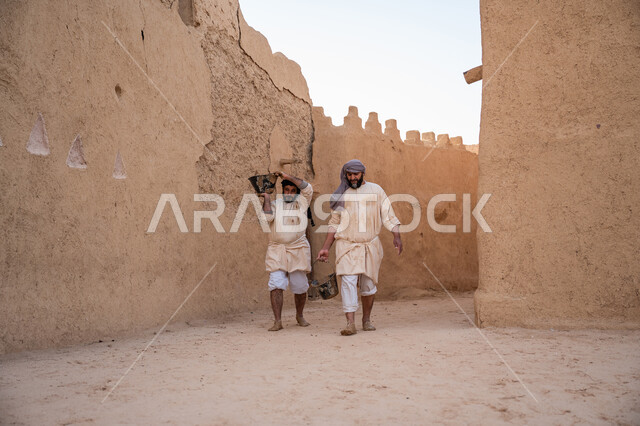 إحياء ذكرى يوم التأسيس1727 م, بناء الدولة السعودية الأولى, عاملان عربيان يقومان بنقل الطين ومواد البناء, يوم بدينا 22 فبراير, الفخر والاعتزاز بالتراث السعودي العريق, تشييد وبناء البيوت الطينية التراثية التاريخية