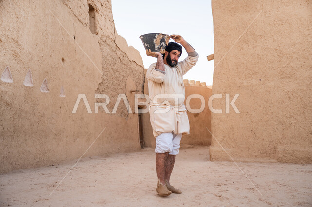 The day we started is February 22, pride and honor in the ancient Saudi heritage, construction and building of historical heritage mud houses, commemorating the founding day 1727 AD, building the first Saudi state, an Arab worker transporting mud and building materials