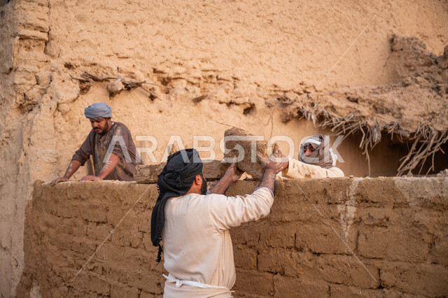 إحياء ذكرى يوم التأسيس1727 م, بناء الدولة السعودية الأولى, يوم بدينا 22 فبراير, الفخر والاعتزاز بالتراث السعودي العريق, عمال عرب يقومون ببناء بيت طيني شعبي, تشييد وبناء البيوت الطينية التراثية التاريخية