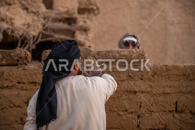 تشييد وبناء البيوت الطينية التراثية التاريخية, إحياء ذكرى يوم التأسيس1727 م, بناء الدولة السعودية الأولى, يوم بدينا 22 فبراير, الفخر والاعتزاز بالتراث السعودي العريق, عاملان عربيان يقومان ببناء بيت طيني شعبي