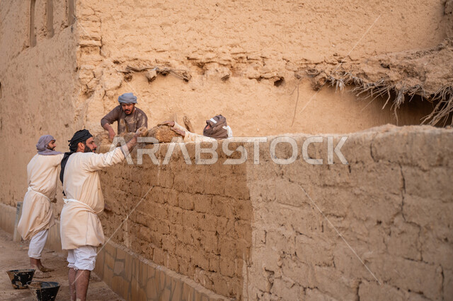 إحياء ذكرى يوم التأسيس1727 م, بناء الدولة السعودية الأولى, يوم بدينا 22 فبراير, الفخر والاعتزاز بالتراث السعودي العريق, عمال عرب يقومون ببناء بيت طيني شعبي, تشييد وبناء البيوت الطينية التراثية التاريخية