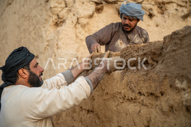 بناء الدولة السعودية الأولى, يوم بدينا 22 فبراير, الفخر والاعتزاز بالتراث السعودي العريق, عاملان عربيان يقومان ببناء بيت طيني شعبي, تشييد وبناء البيوت الطينية التراثية التاريخية, إحياء ذكرى يوم التأسيس1727 م