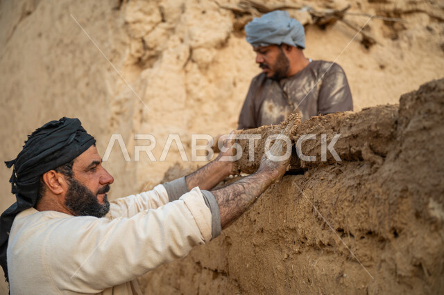 تشييد وبناء البيوت الطينية التراثية التاريخية, إحياء ذكرى يوم التأسيس1727 م, بناء الدولة السعودية الأولى, يوم بدينا 22 فبراير, الفخر والاعتزاز بالتراث السعودي العريق, عاملان عربيان يقومان ببناء بيت طيني شعبي
