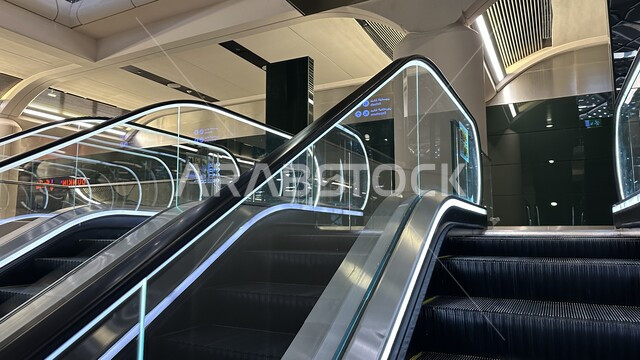 Electric stairs for easy ascent and descent of pilgrims and Umrah performers, Haramain High Speed ​​Railway Station in the Kingdom of Saudi Arabia, a comfortable means of transportation, the engineering art of developing and advancing means of transportation, a fast electric line linking Mecca and Medina, the ability to move from one area to another