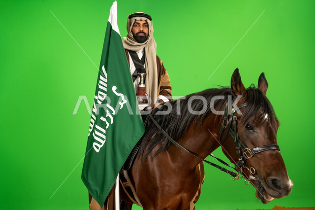 ذكرى تأسيس الدولة السعودية الأولى1727م, الفخر والاعتزاز بالهوية الوطنية، شغف تربية ورعاية الخيل، اليوم الوطني السعودي 23 سبتمبر، بورتريه لرجل عربي خليجي سعودي يرتدي الزي الشعبي يمتطي فرس عربي يحمل علم التأسيس، يوم بدينا 22 فبراير، خلفية خضراء، كروما