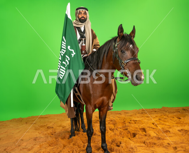 يوم بدينا 22 فبراير، ذكرى تأسيس الدولة السعودية الأولى1727م, الفخر والاعتزاز بالهوية الوطنية، شغف تربية ورعاية الخيل، اليوم الوطني السعودي 23 سبتمبر، بورتريه لرجل عربي خليجي سعودي يرتدي الزي الشعبي يمتطي فرس عربي يحمل علم التأسيس فوق الرمال الناعمة، خلفية خضراء، كروما