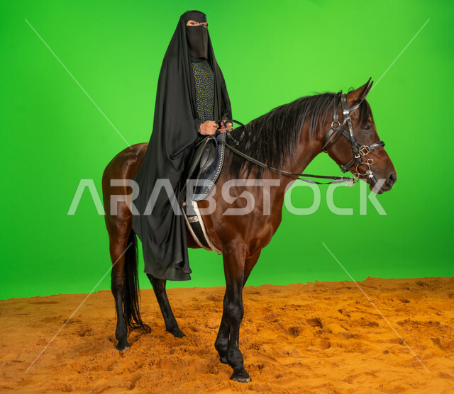 ذكرى تأسيس الدولة السعودية الأولى1727م, الفخر والاعتزاز بالهوية الوطنية، شغف تربية ورعاية الخيل، اليوم الوطني السعودي 23 سبتمبر، بورتريه لامرأة عربية خليجية سعودية ترتدي البرقع والعباءة تمتطي فرس عربي فوق الرمال الناعمة, يوم بدينا 22 فبراير، خلفية خضراء، كروما