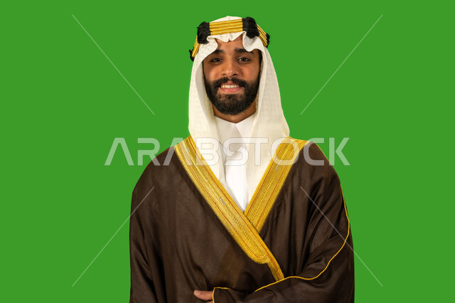 يوم بدينا22 فبراير، ذكرى تأسيس الدولة السعودية الأولى1727م, ارتداء الزي الشعبي في مناسبة وطنية, الفخر والاعتزاز بالهوية الوطنية، بورتريه مقرب لرجل عربي خليجي سعودي يرتدي البشت والعقال ينظر للكاميرا ويقف باستقامة وشموخ، خلفية خضراء، كروما