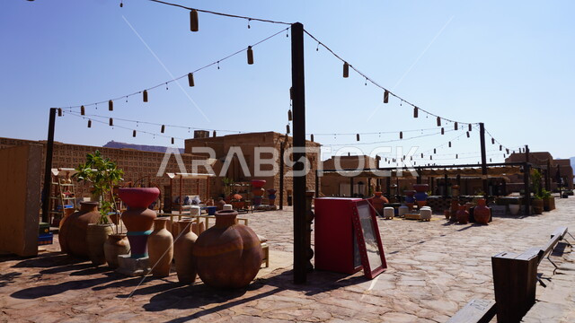 أكشاك بيع الجرات الفخار الشعبية والجرار التراثية في سوق البلدة القديمة، الاماكن التاريخية الأثرية, السياحة في مدينة العلا, مكان لجذب واستقطاب السياح من أنحاء العالم، منطقة سياحية مشهورة في المملكة العربية السعودية، منتج محلي وطني