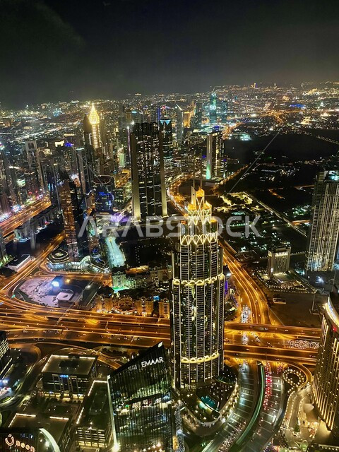 Modern architecture, top view of Burj Khalifa illuminated at night in Dubai, urban growth and development of towers and skyscrapers in UAE, traffic on street