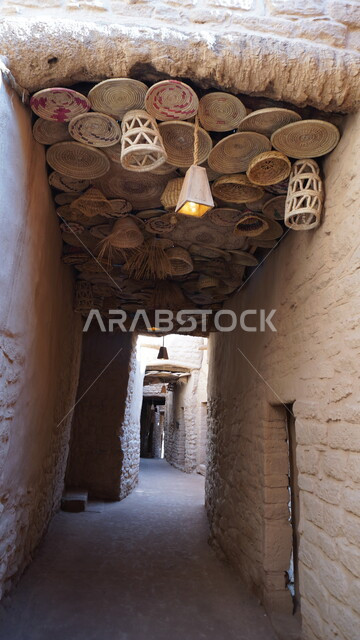 مبنى تاريخي أثري, السياحة في مدينة العلا، ممر ضيق مسقوف بمجموعة من الأواني المعدنية المعلقة في البلدة القديمة, منطقة سياحية مشهورة في المملكة العربية السعودية، الفن الهندسي المعماري على الطراز القديم