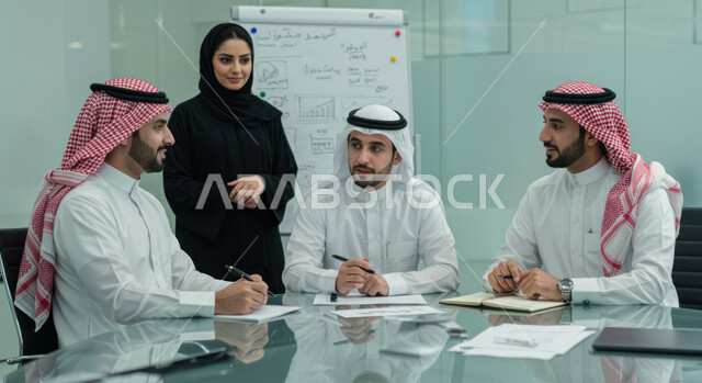 التطور المهني في شركات المملكة العربية السعودية، مناقشة وتوزيع المهام, تطوير الخطط وحل المشكلات لتحقيق الأهداف، زملاء عرب سعوديين خليجيين يقومون باجتماع داخل مقر الشركة, العمل الجماعي وروح الفريق الواحد