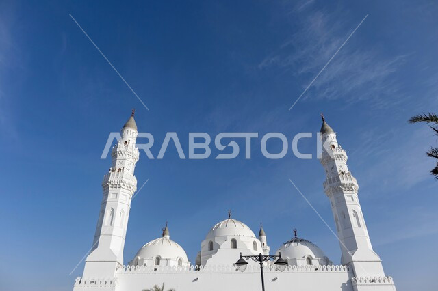 Performing the obligatory prayer on time, the concept of worship and drawing closer to God Almighty, the architectural art of the domes and minarets of mosques in the Islamic style, a sacred religious landmark in the Kingdom of Saudi Arabia, Quba Mosque in Medina during the day