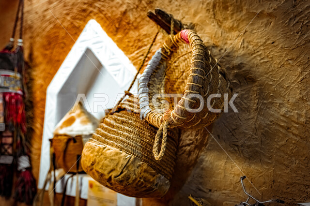 ذكرى تأسيس الدولة السعودية الأولى ١٧٢٧م، تحفة أثرية على الطراز القديم، يوم بدينا 22 فبراير، الانتيكات و التحف التقليدية، صورة مقربة لسلة من القش معلقة على جدار طيني، معدات و أدوات خليجية شعبية