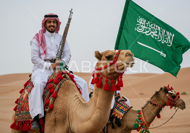 الاحتفال بالأعياد والمناسبات الوطنية، استذكار اليوم الوطني السعودي 23 سبتمبر، ذكرى يوم العلم 11 مارس, رجل عربي خليجي سعودي يرتدي الثوب التقليدي والشماغ يمتطي الجمل ويحمل بيده البندقية، علم المملكة العربية السعودية يرفرف في السماء، مفهوم الاعتزاز والفخر بالوطن