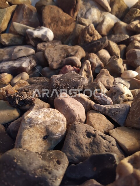 صورة مقربة لأحجار وحصوات على شاطئ البحر ، خلفية لصخور وحصوات شاطئ البحر الصغيرة ، حصى الشواطئ الطبيعية  ، صخور بحرية صغيرة