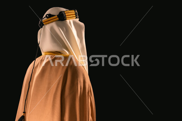 حب الوطن والانتماء إليه, ذكرى تأسيس الدولة السعودية الأولى 1727م، يوم بدينا 22 فبراير، الفخر بإنجازات المملكة، بورتريه مقرب من الجانب لرجل عربي خليجي سعودي يرتدي الغترة والعقال الذهبي والبشت ينظر إلى شيء ما، خلفية سوداء