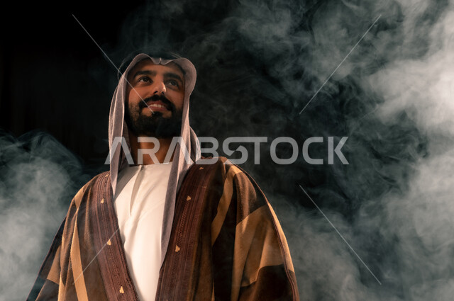 الفخر بإنجازات المملكة، بورتريه مقرب لرجل عربي خليجي سعودي يرتدي الغترة والبشت ينظر إلى شيء ما في الأعلى بإيماءات الشموخ، ذكرى تأسيس الدولة السعودية الأولى 1727م، يوم بدينا 22 فبراير، حب الوطن والانتماء إليه, خلفية سوداء