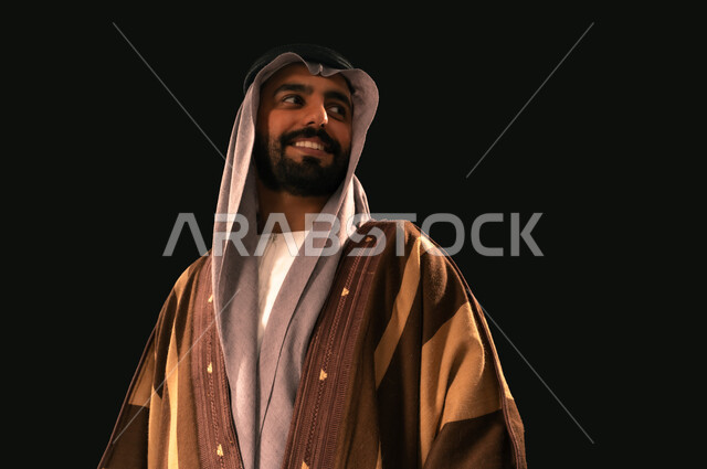 Anniversary of the founding of the first Saudi state 1727 AD, pride in the achievements of the Kingdom, close-up portrait of a Saudi Gulf Arab man wearing a ghutra and a bisht looking at something with gestures of pride, the day we started, February 22, love of the homeland and belonging to it, black background