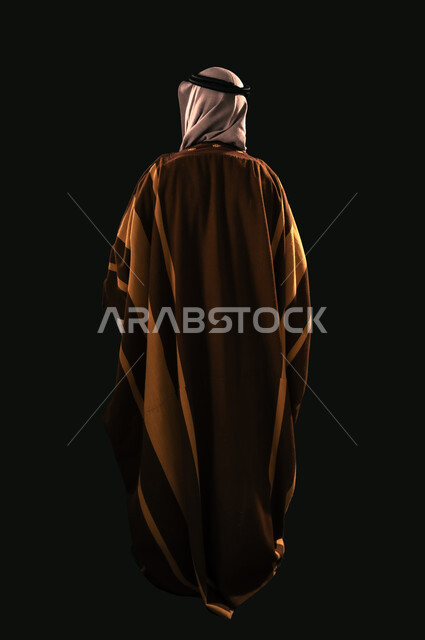 يوم بدينا 22 فبراير، الفخر بإنجازات المملكة، بورتريه من الخلف لرجل عربي خليجي سعودي يرتدي الغترة والبشت ينظر إلى شيء ما، حب الوطن والانتماء إليه, ذكرى تأسيس الدولة السعودية الأولى 1727م، الجسم بالطول الكامل، خلفية سوداء