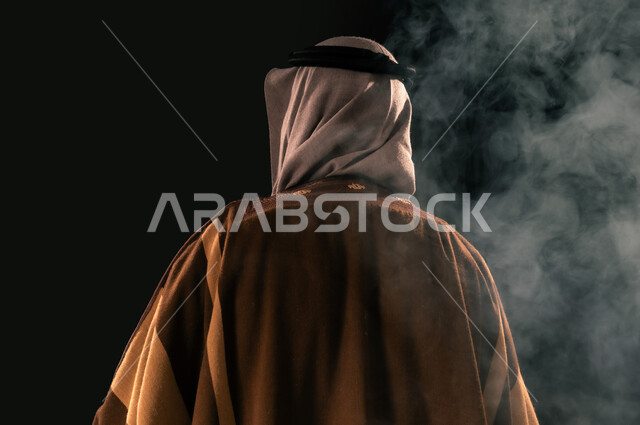 ذكرى تأسيس الدولة السعودية الأولى 1727م، يوم بدينا 22 فبراير، الفخر بإنجازات المملكة، بورتريه مقرب من الخلف لرجل عربي خليجي سعودي يرتدي الغترة والبشت ينظر إلى شيء ما، حب الوطن والانتماء إليه, خلفية سوداء