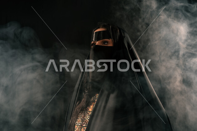 ذكرى تأسيس الدولة السعودية الأولى 1727م، حب الوطن والانتماء إليه, الفخر بإنجازات المملكة، بورتريه مقرب لامرأة عربية خليجية سعودية ترتدي البرقع والعباءة تنظر إلى شيء ما بإيماءات الشموخ، يوم بدينا 22 فبراير، خلفية سوداء