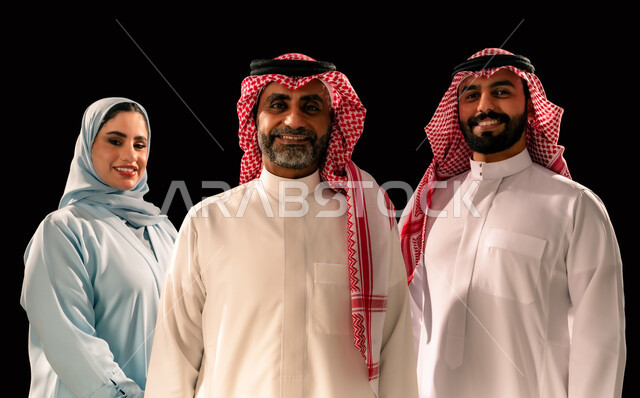 الاناقة والاهتمام بالمظهر الخارجي, النظر الى الكاميرا بتعابير السرور, بورتريه مقرب لعائلة عربيه خليجيه سعودية مبتسمة تقف باستقامة, مفهوم المحبة و المودة بين أفراد الاسرة, ارتداء الازياء التقليدية, خلفية سوداء