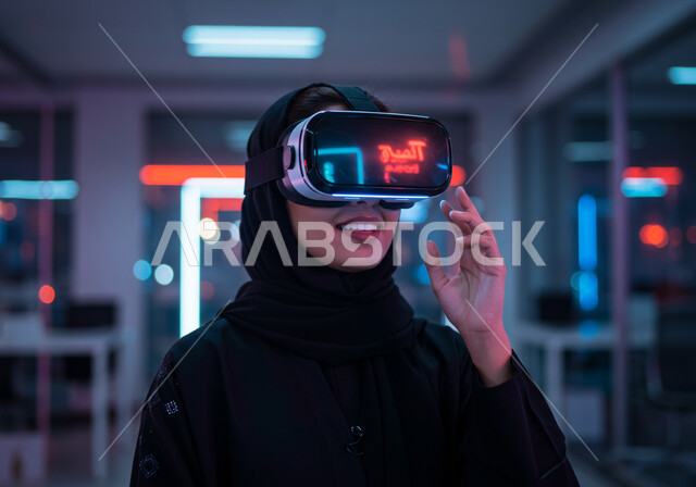 الاندماج والتفاعل مع العناصر الهولوجرامية، محاكاه العالم الخيالي، استخدام الأجهزة التقنية الحديثة والمتطورة، صورة مقربة لامرأة عربية خليجية سعودية محجبة ترتدي عباءة سوداء وتضع نظارة الواقع الافتراضي، مفهوم التطور التقني والتكنولوجي، ايماءات محاولة الامساك بشيء ما