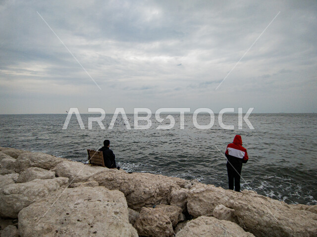 كورنيش الخبر في مدينة الدمام، جذب واستقطاب السائحين من جميع أنحاء العالم، صورة من الخلف لشخصين يستمتعان أمام البحر، مكان سياحي ساحلي مشهور في المملكة العربية السعودية, منطقة للاستمتاع برحلة عائلية ترفيهية