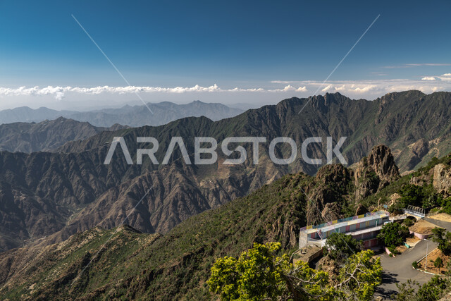 الشجر والنبات المغطي سفوح الجبل، التضاريس والبيئة الجبلية لمنطقة أبها في عسير، الطبيعة والمنتزهات والحدائق الخضراء، سلاسل الجبال الصخرية والقمم العالية في وقت النهار،  أماكن طبيعية للمغامرات ورحلات السفاري والاستمتاع