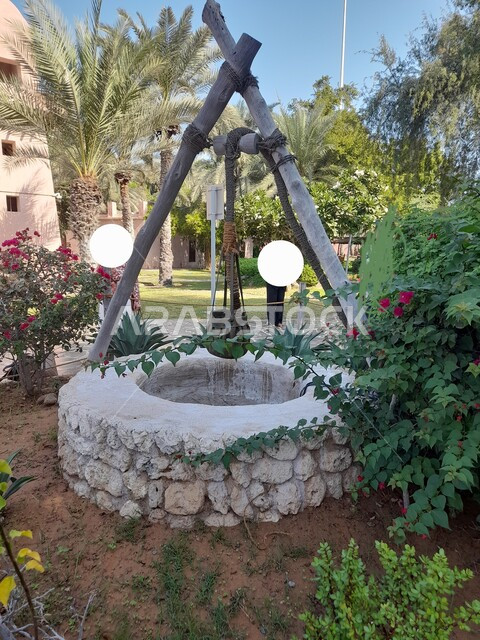 بئر ماء قديم في قصر الحصن في أبوظبي بجانب الكورنيش كاسر الأمواج في النهار, بئر عميق مبني على الطراز التراثي، الاماكن والمعالم السياحية في الامارات العربية المتحدة, الاهتمام بزراعة الاشجار
