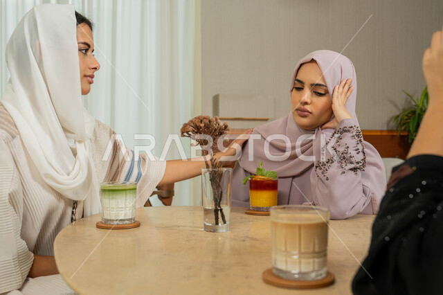 تخفيف الحزن والمواساه، ايماءات التعب والارهاق والملل، التسامر والدردشة وقضاء وقت مع الأصدقاء، كوفي شوب راقي بالامارات، تطوير العلاقات الإجتماعية، صديقات عربيات خليجيات اماراتيات يجلسن على طاولة في المقهى، نساء سعوديات يتبادلون الحديث